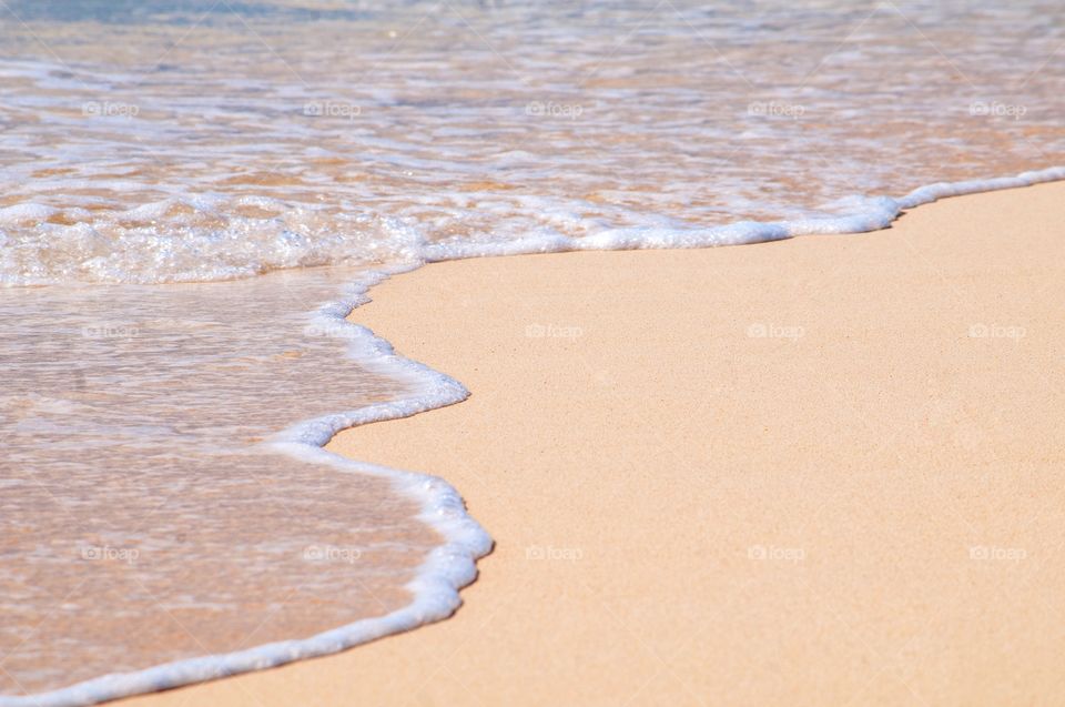 Clear beautiful waves roll over the white sand beach of Grand Turk. 
