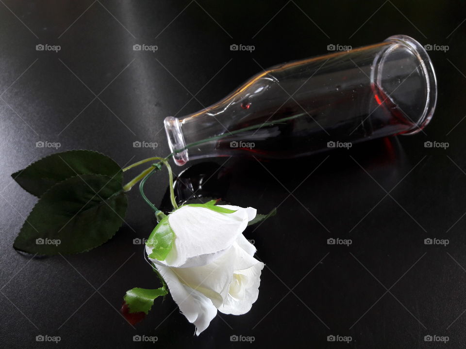 Fake rose flower with glass bottle