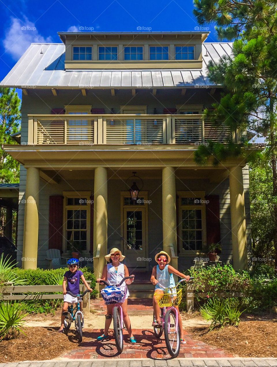 Three girls on bike in front of the beach house 