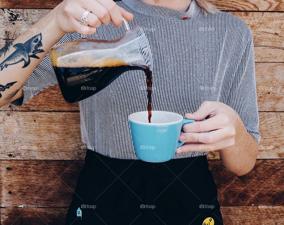 This girl pouring coffee the only way she knows how. 