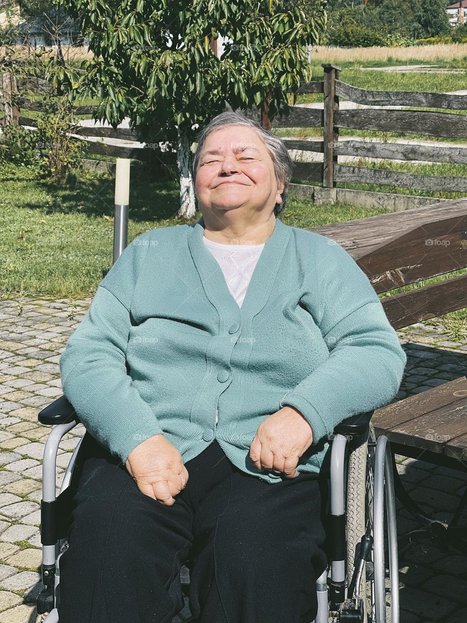 Portrait of a smiling elderly woman in a wheelchair