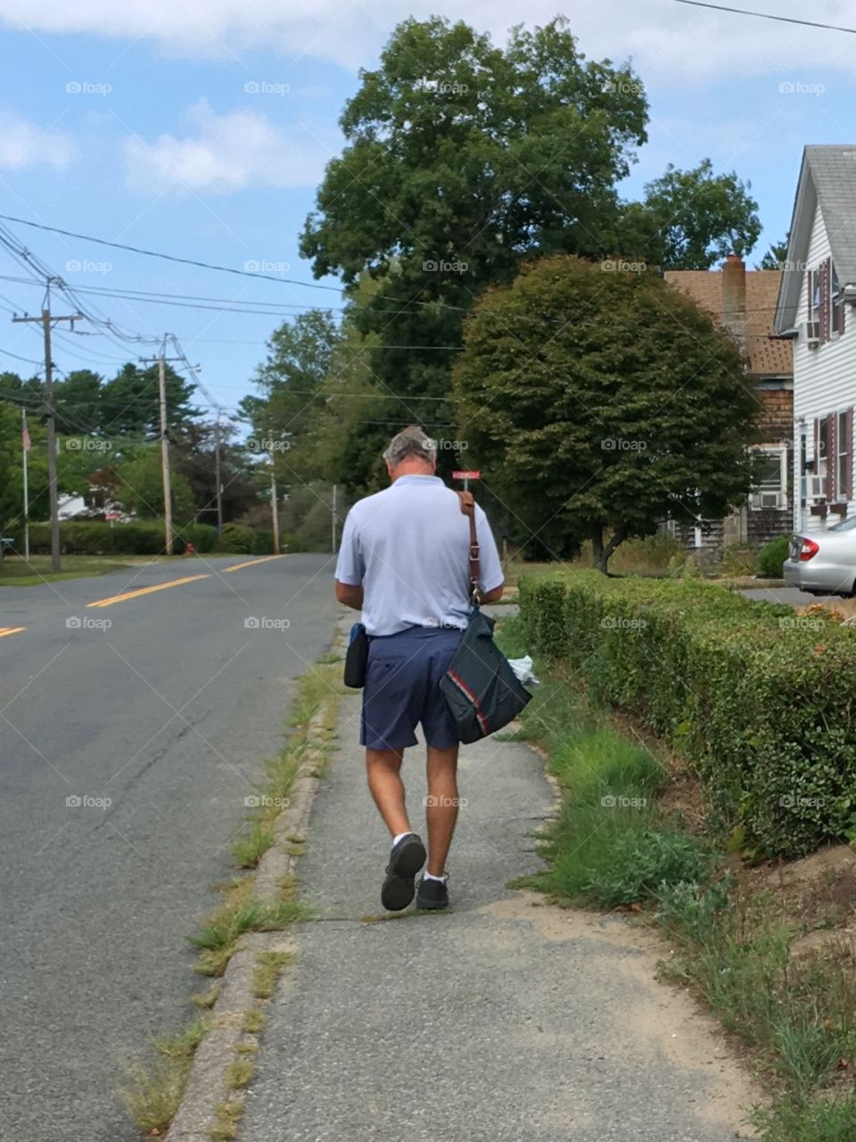 US Postal Service delivering mail to homes while walking.