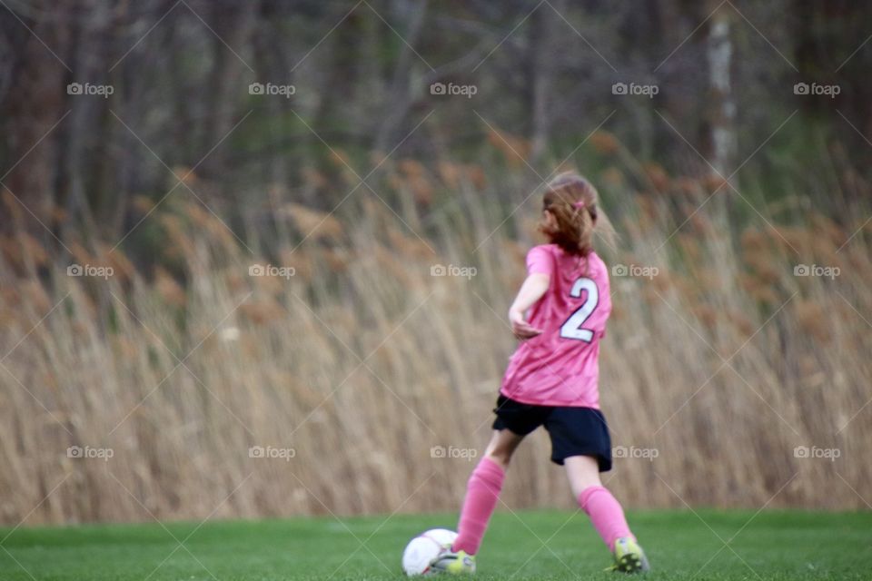 Girl kicking soccer ball