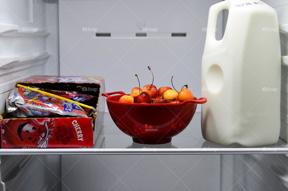 Cherry Kool-Aid case shown in an open refrigerator next to a bowl of cherries