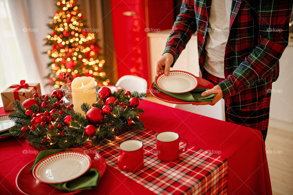 man sets a beautiful decorated winter table for a festive dinner.  Merry Christmas and Happy New Year.