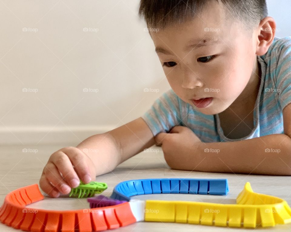 Asian boy playing with colourful toys 
