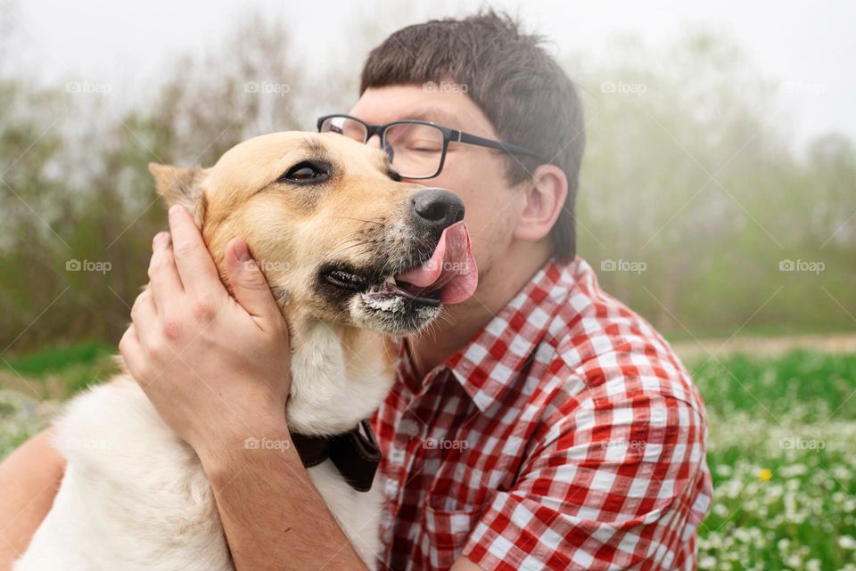 man kissing dog