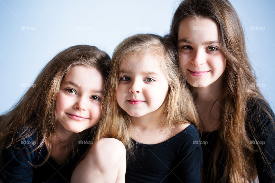 beautiful three sisters hug and laugh. Portrait