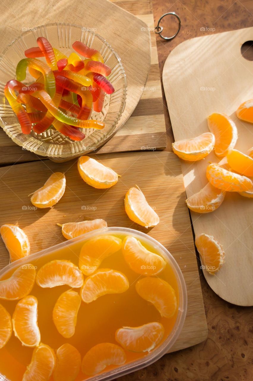 Delicious orange jelly with tangerine slices in a container and jelly worms.