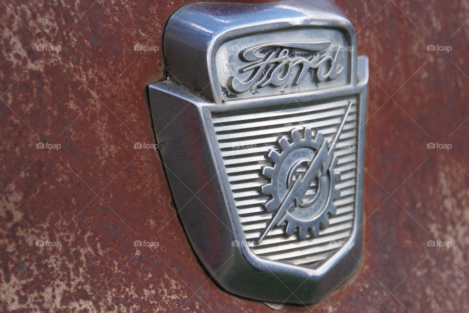 Macro photography of old vintage Ford Emblem on rusty truck 