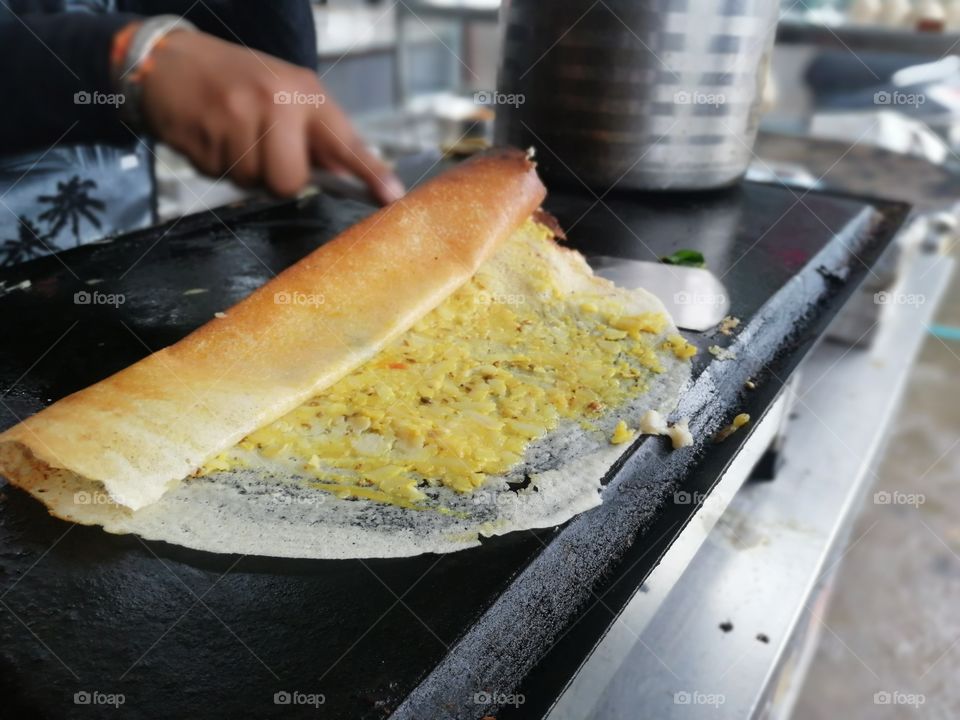 A dosa is a cooked flat thin layered rice batter, originating from the South India, made from a fermented batter. It is somewhat similar to a crepe in appearance. Its main ingredients are rice and black gram.