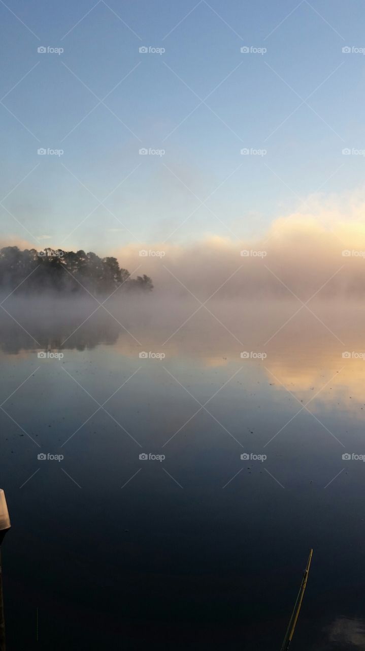 Sunrise, foggy morning on the lake