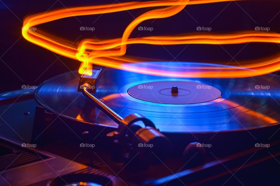disk of an old loudspeaker in different colors, long exposure photo with light trails  personifying the flight of melody in the air