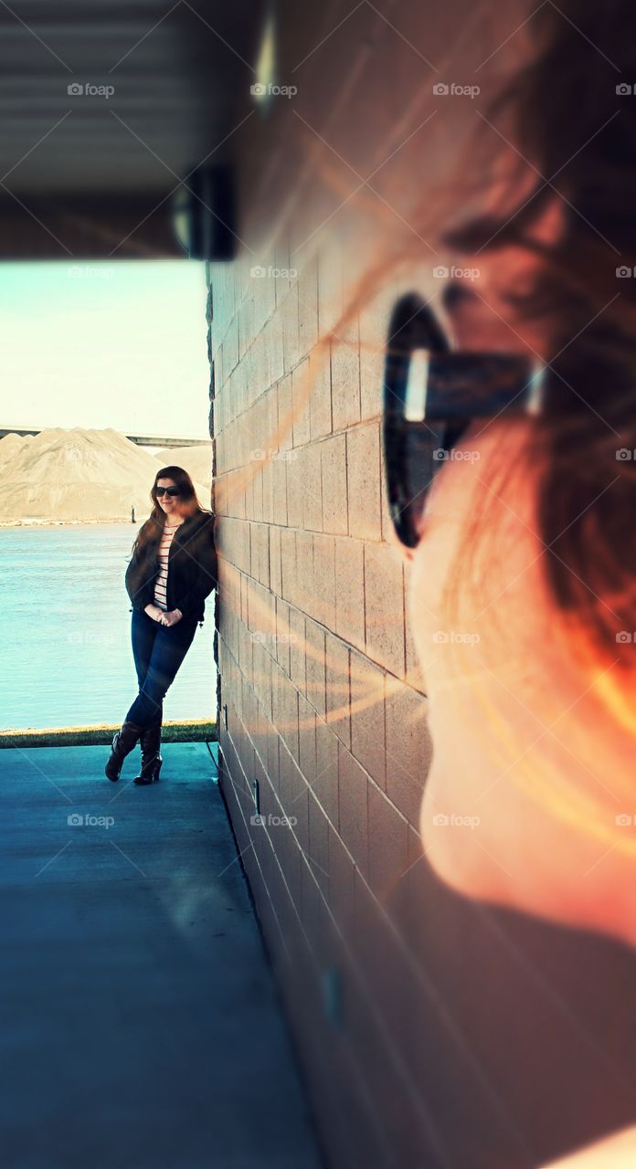 Stylish woman standing near the wall