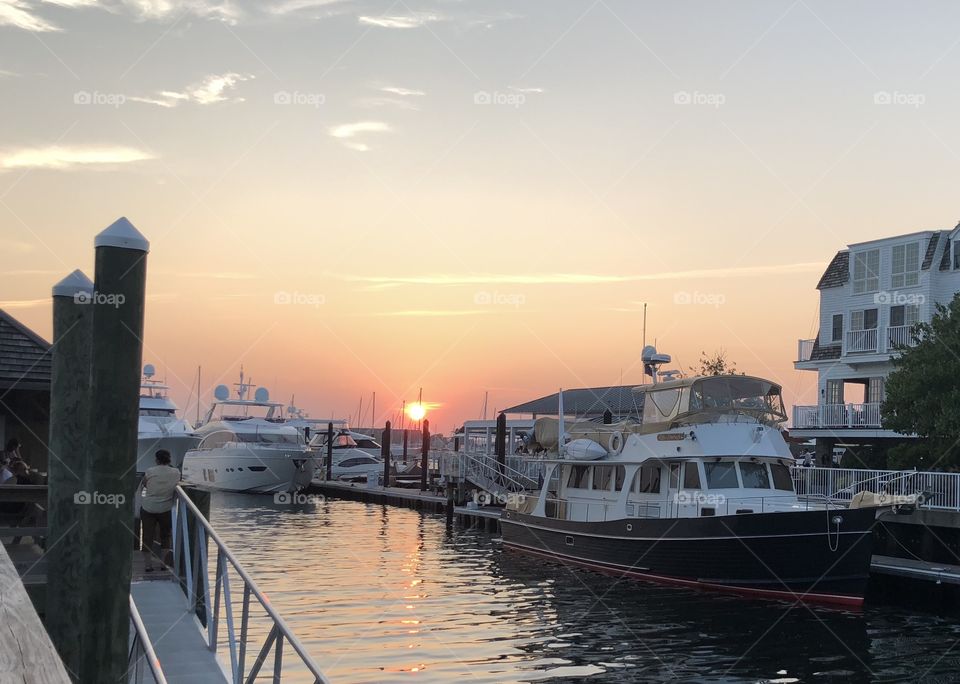 The sun sets over the yachts on Newport Harbor 