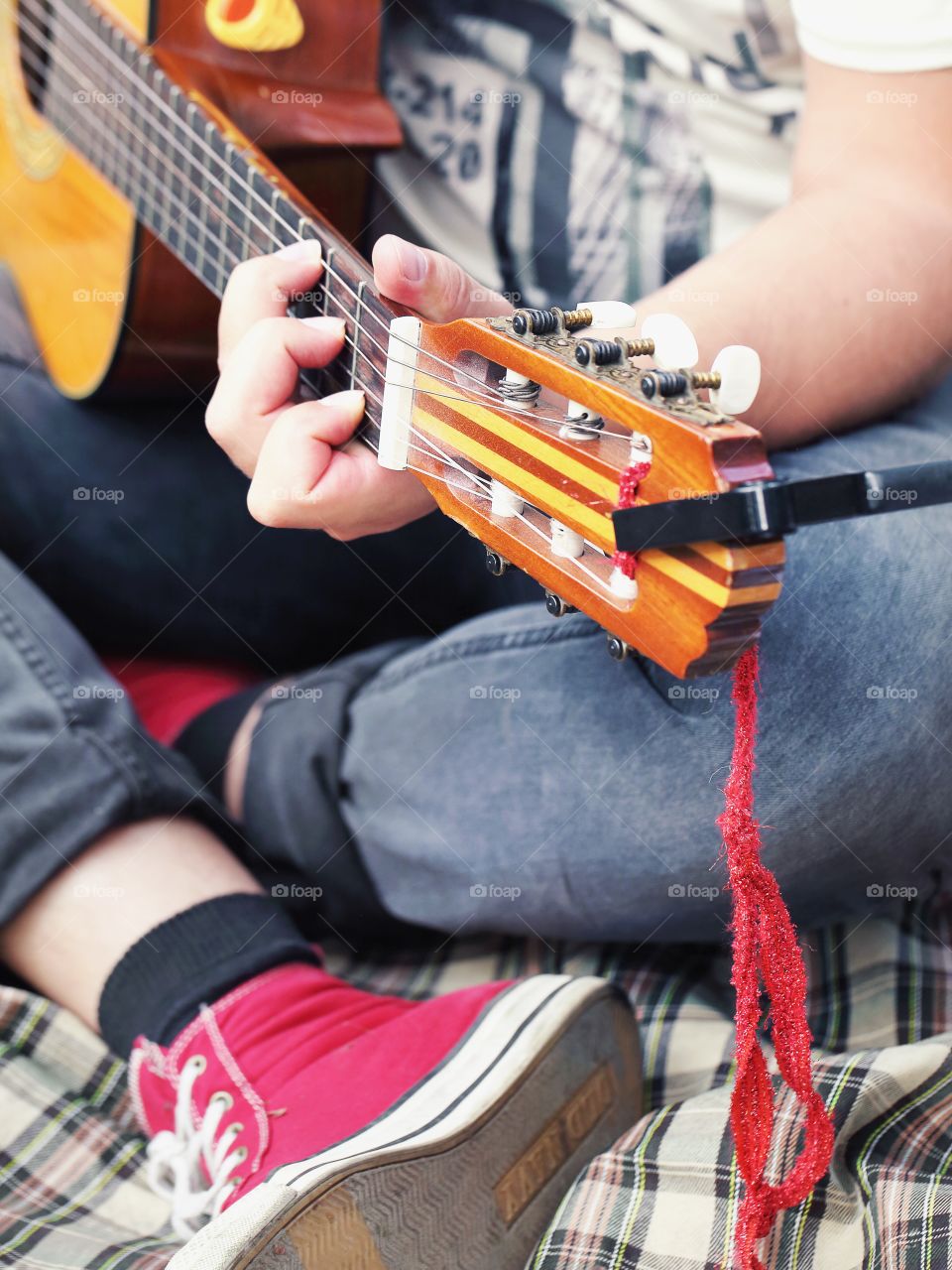 man in red sneakers playing guitar
