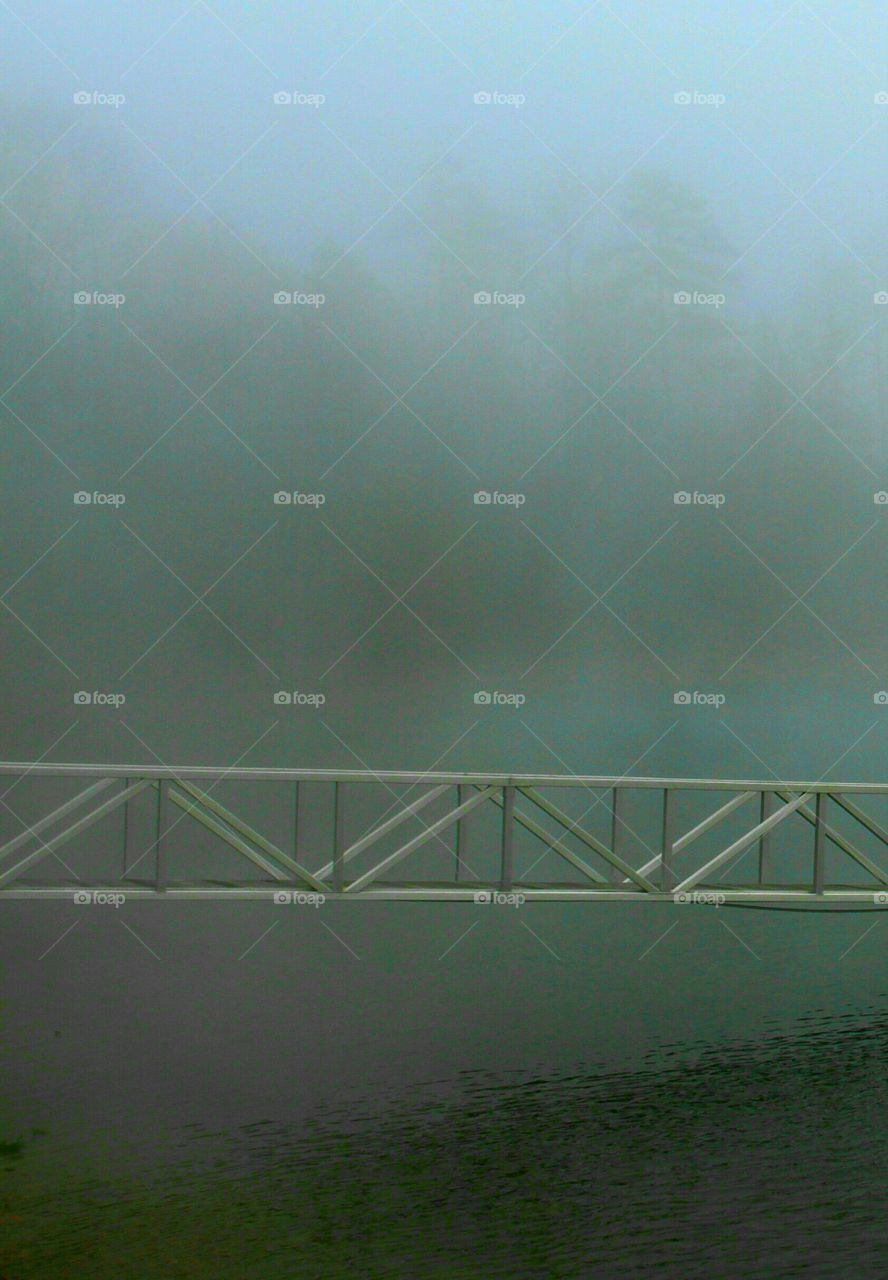 gamgplank leading to a dock but obscured by fog.