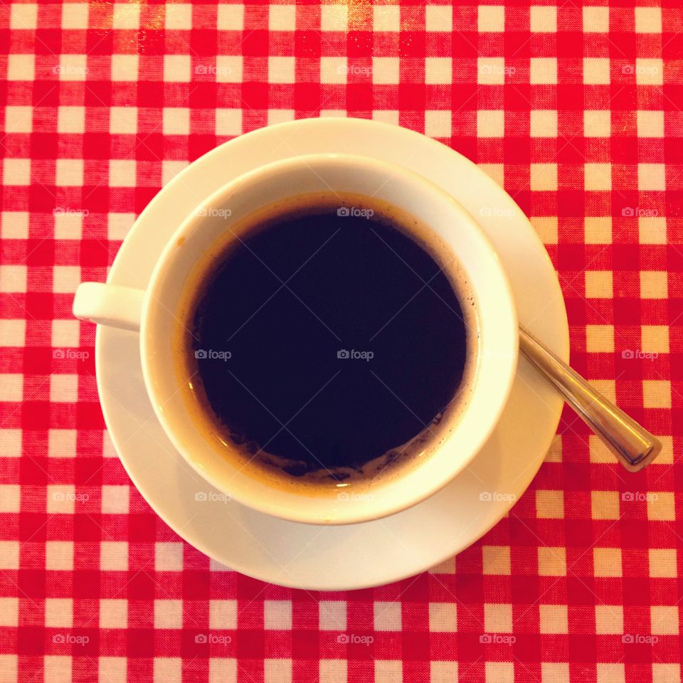 Cup of coffee. Cup of coffee on a red gingham tablecloth