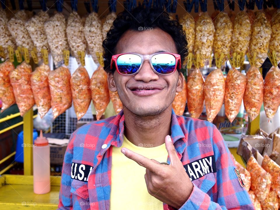 an asian man wearing sunglasses and smiling