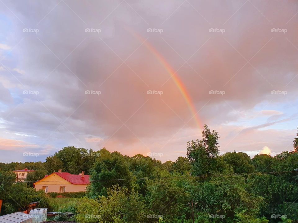 Bright double rainbow in the small village. Colorful background.