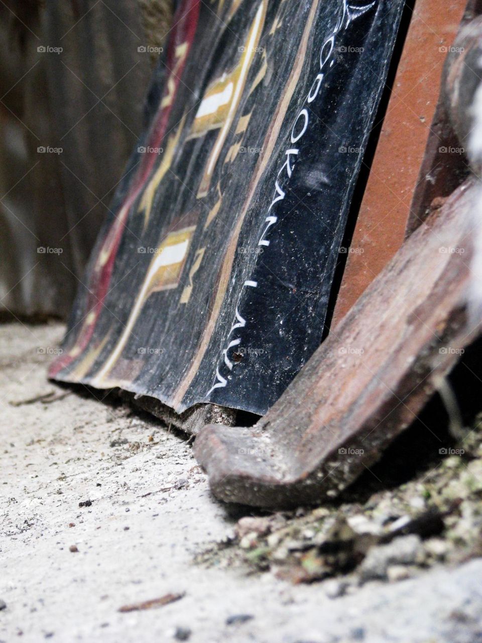 Banyumas, Central Java, Indonesia - January 20, 2024: Close-up of a piece of wood that appears to be part of a plank or similar object, with text written on it, placed on the ground or rough surface