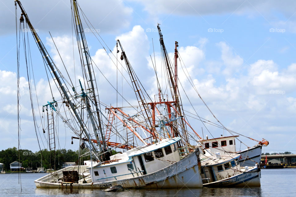 Three shrimp boats sinking on river