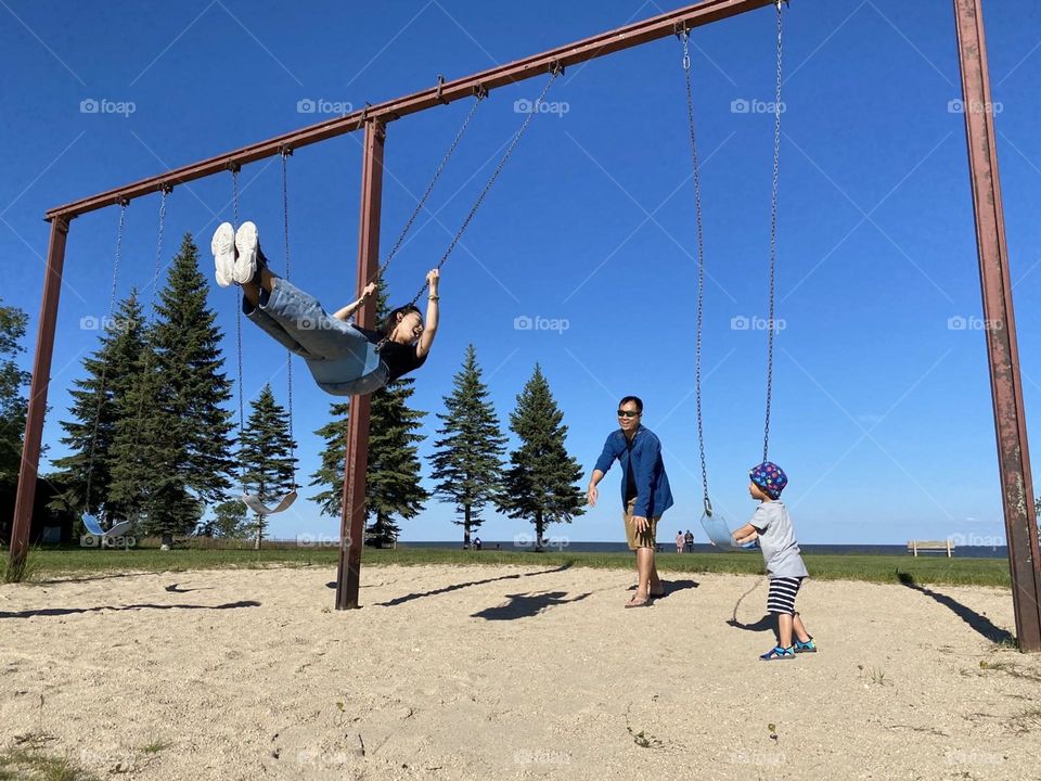 Family is playing the swings