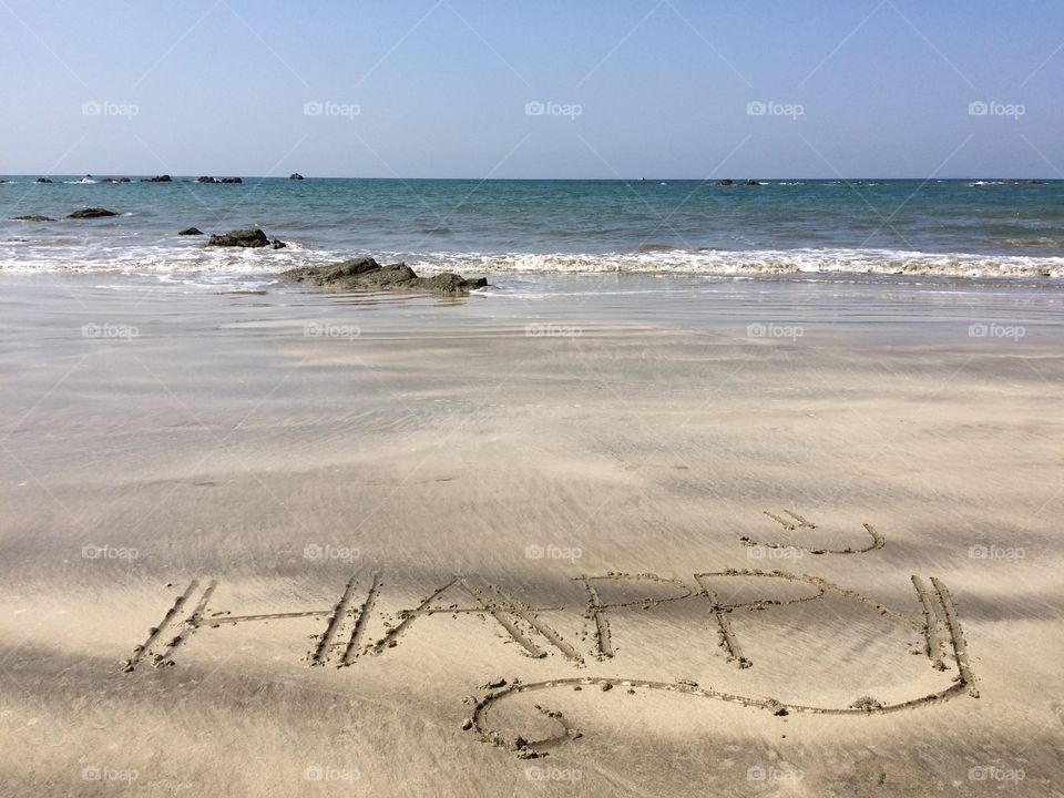 "Happy" writing on sand