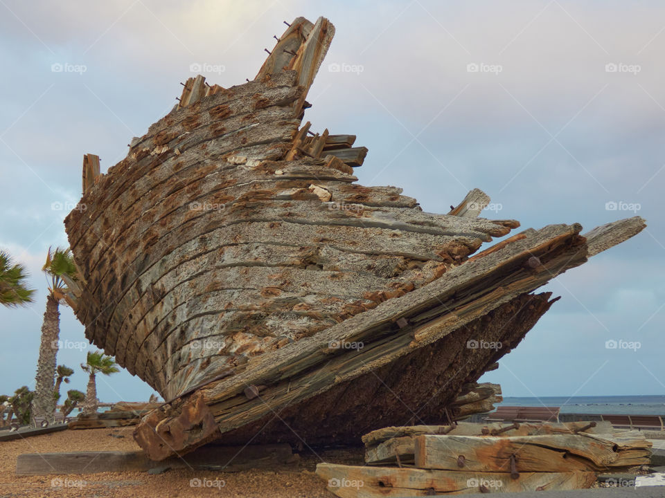 Ruined wooden fishing boat placed in park as decoration