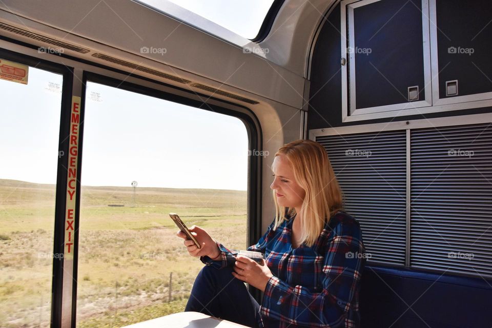 Woman drinking coffee and using her mobile device