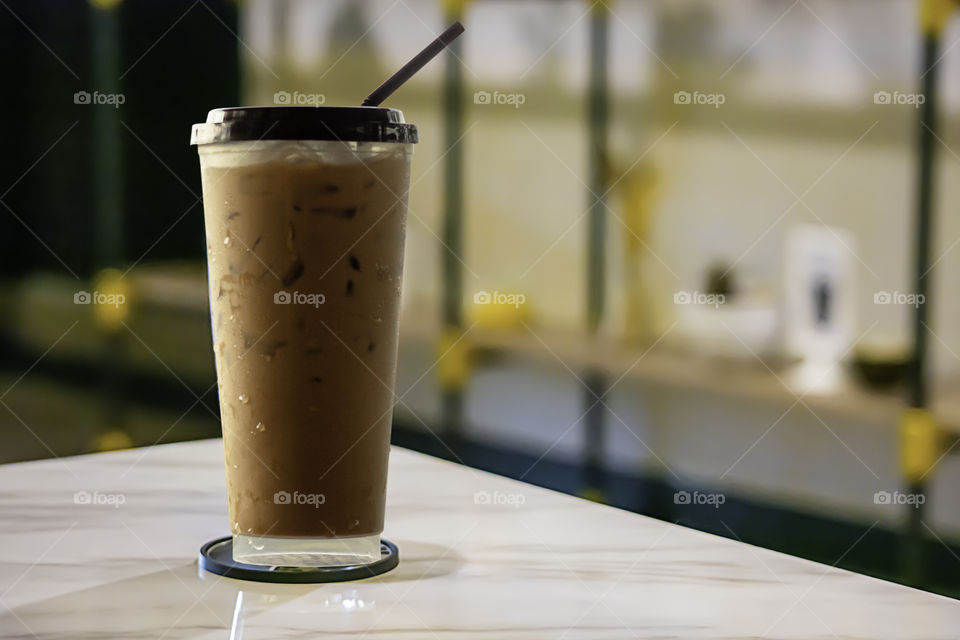 Iced coffee put whipped cream in a glass on the table.