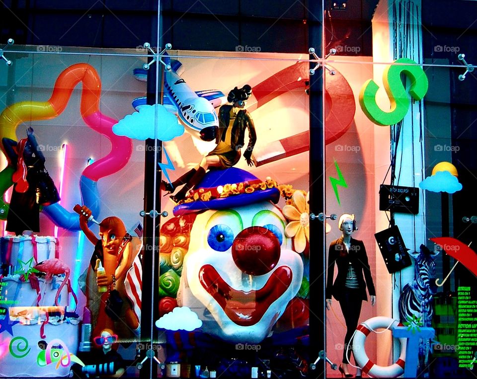 Colourful window dressing at Harvey Nichols in Manchester featuring toys and a clown
