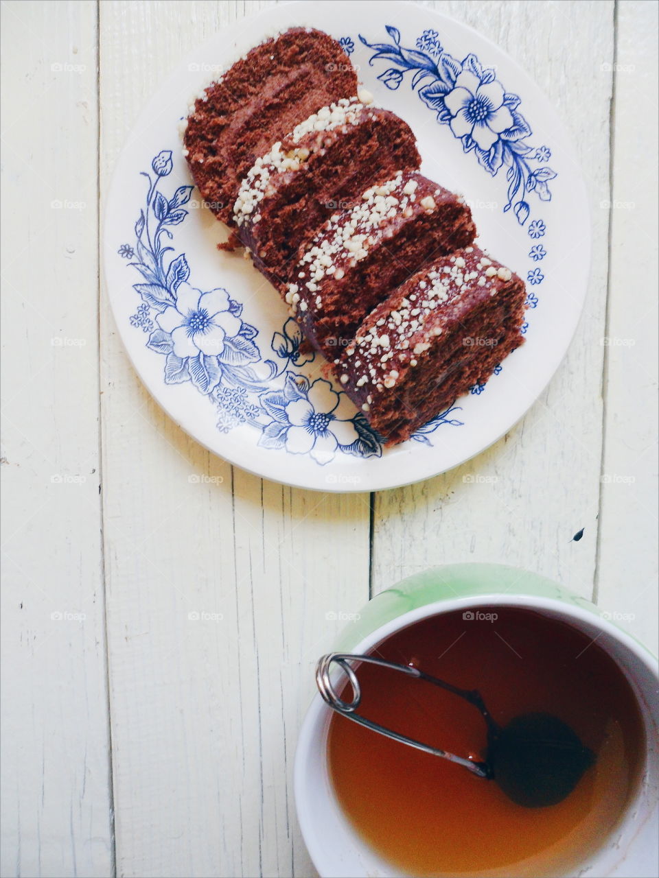 chocolate roll and a cup of black tea on a white background