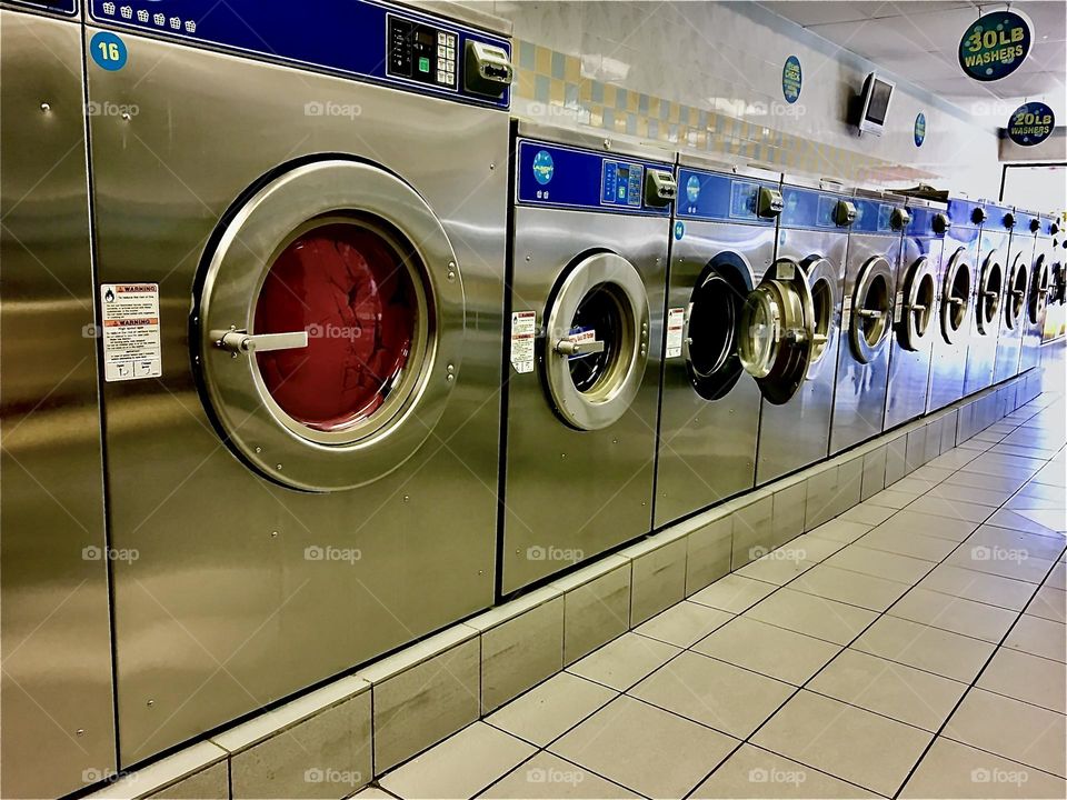 Washing machines at the local laundromat in Long Island City, Queens, NY where we go regularly every few weeks as needed to wash all our stuff. 2021. Hypnotic Productions