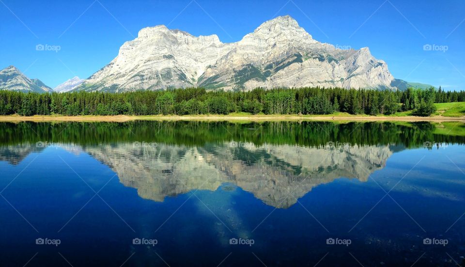 Mountain and trees reflected on lake in Alberta