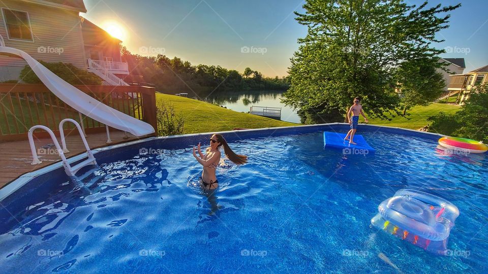long ponytail in bikini in pool at sunset