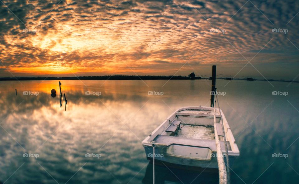 Abandoned boat on the lake at sunset