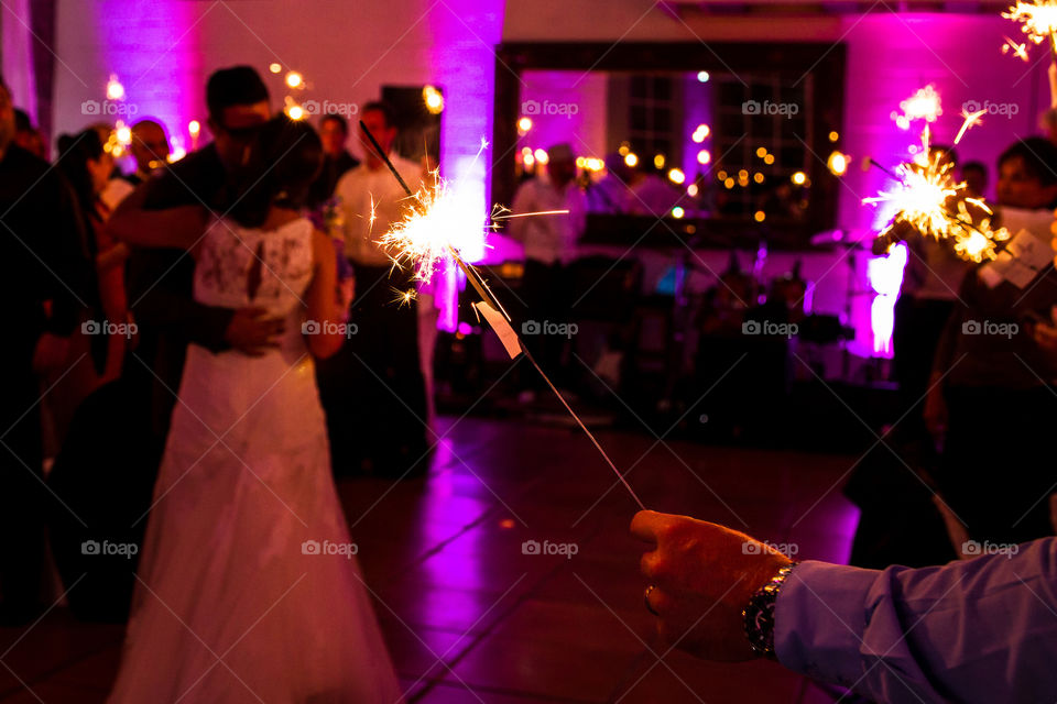 Love the artificial light in this setting with purple backlight and then sparkles in the front with couple dancing in the background.