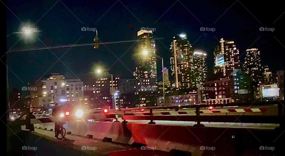 The car lanes of the “Pulaski Bridge” at “Newtown Creek” are especially busy tonight with hustling & bustling of traffic and headlights lit up bright. The red blinking spotlight signals that the bridge is currently closed. 2022. Hypnotic Productions