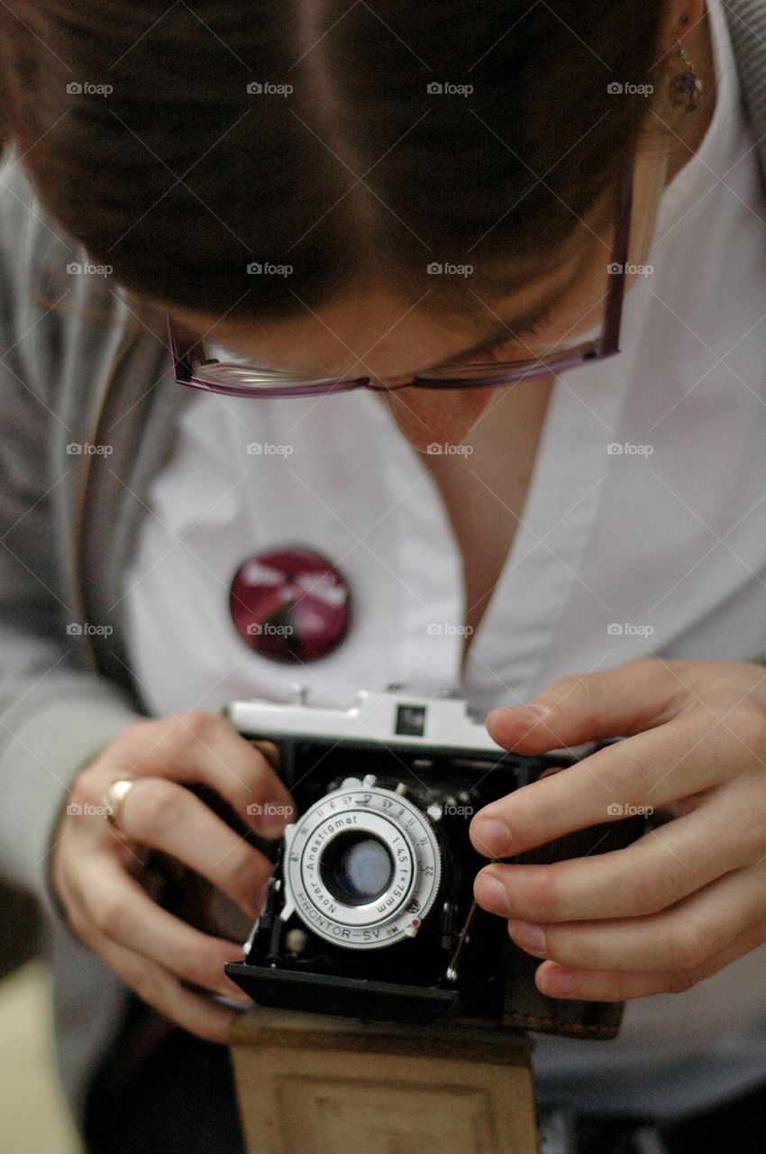 Young woman taking photo using noname retro camera