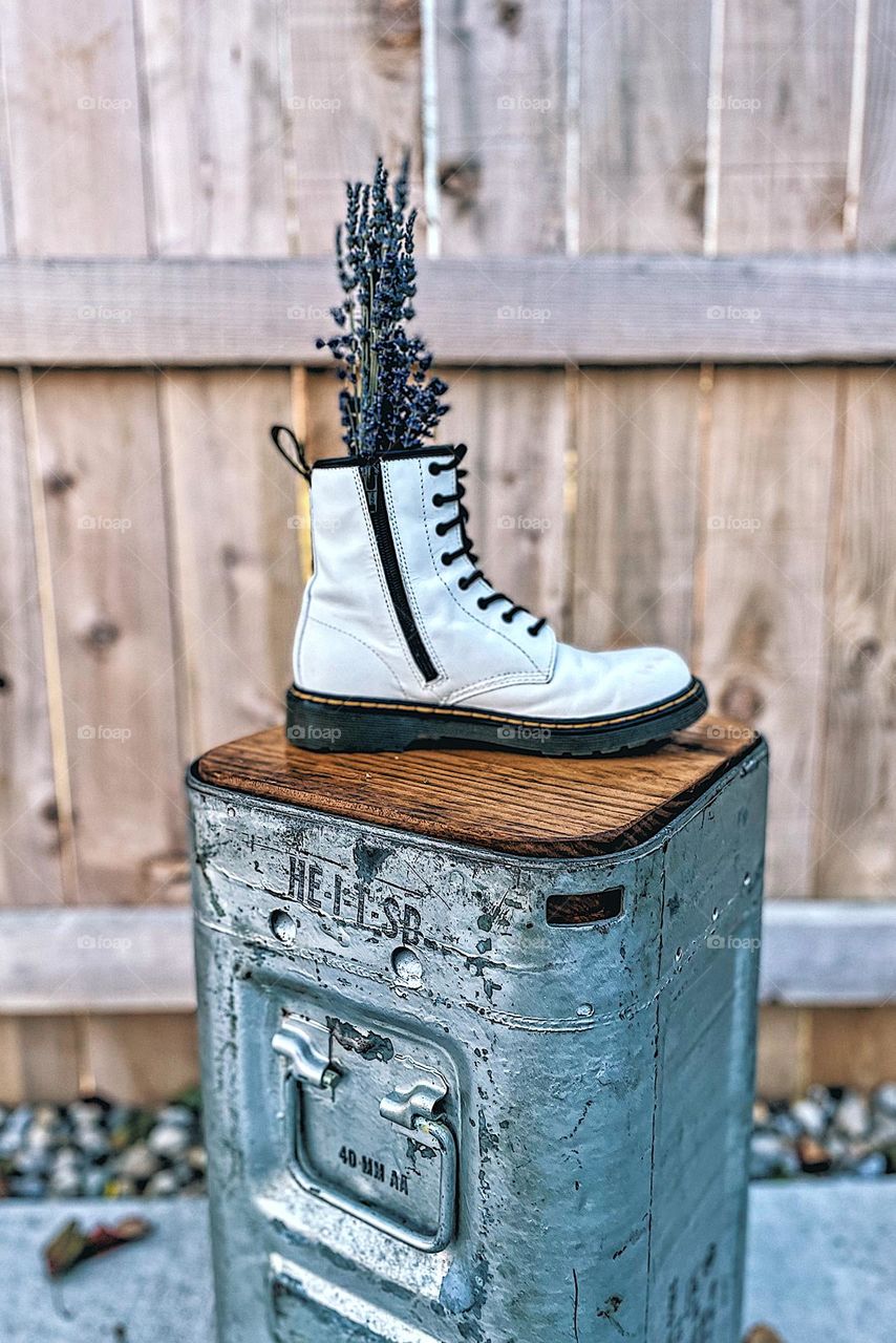 Flowers in an unconventional vase, flowers in a Doc Marten boot, lavender in a white boot, flower bouquet in a boot vase, purple flowers in a white boot, Doc Marten boot used as a vase, boot for a vase, fun way to display flowers 