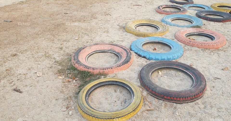 Playground, colored rubbers in the sand, circles, games for children.