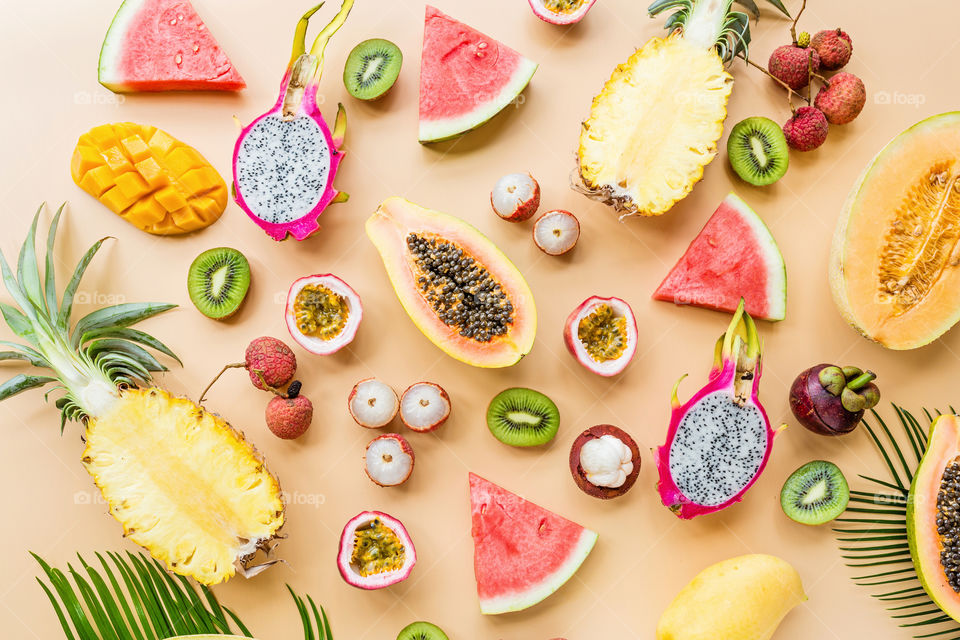 Fresh exotic fruits lying on orange background 