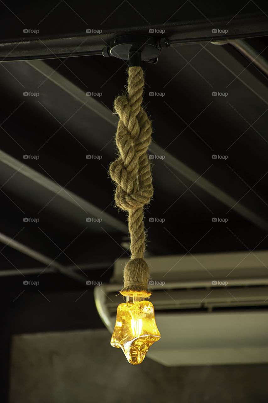 Yellow light bulb The star shaped hanging with a rope.