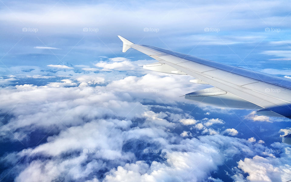 a wing of airplane in the sky from the illuminator