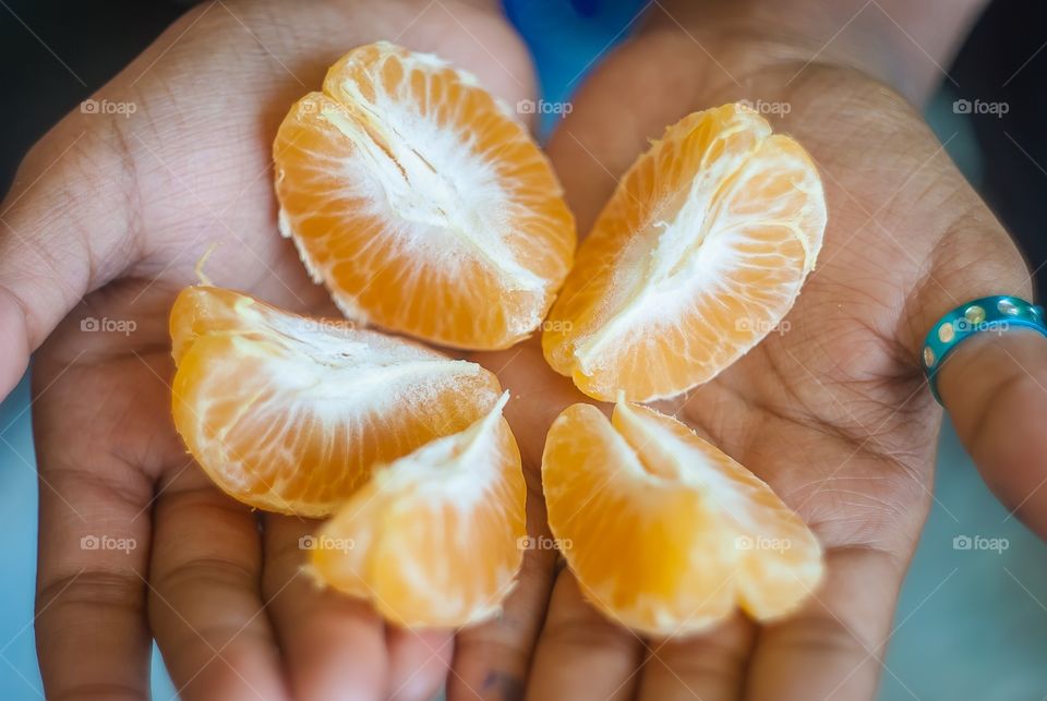 Woman hand holding slices of orange