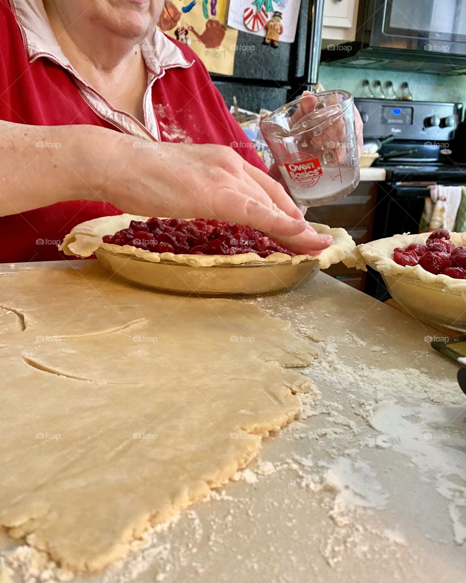 A woman baking cherry pies