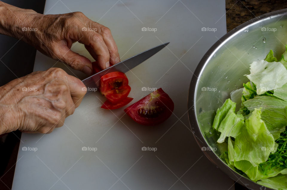 slicing the tomato to put it in the salad.