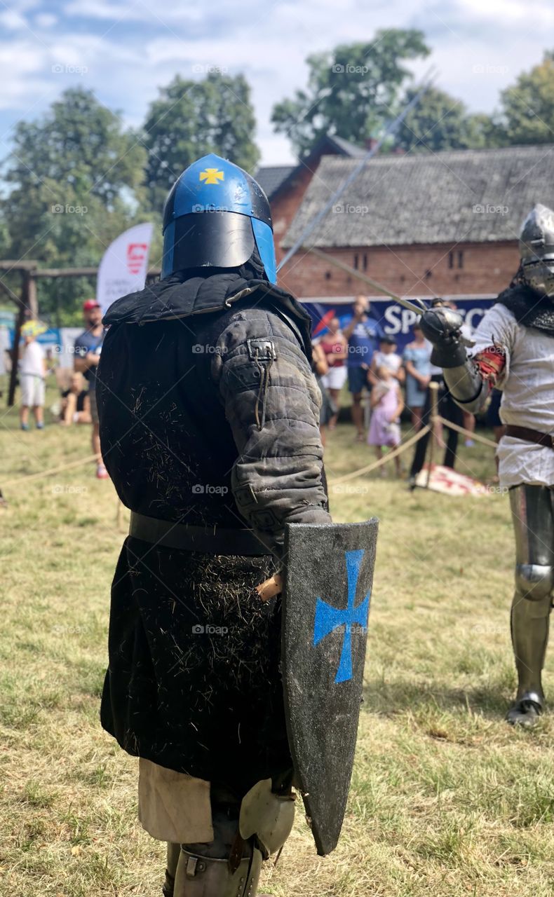 Knight in full armor is preparing for a battle during a reenactment of a battle of medieval knights during a festival in Stronsko, Poland. 
