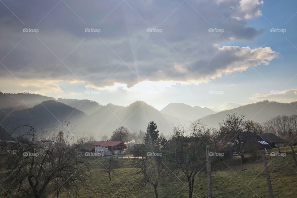 Sunrays crawling under the clouds